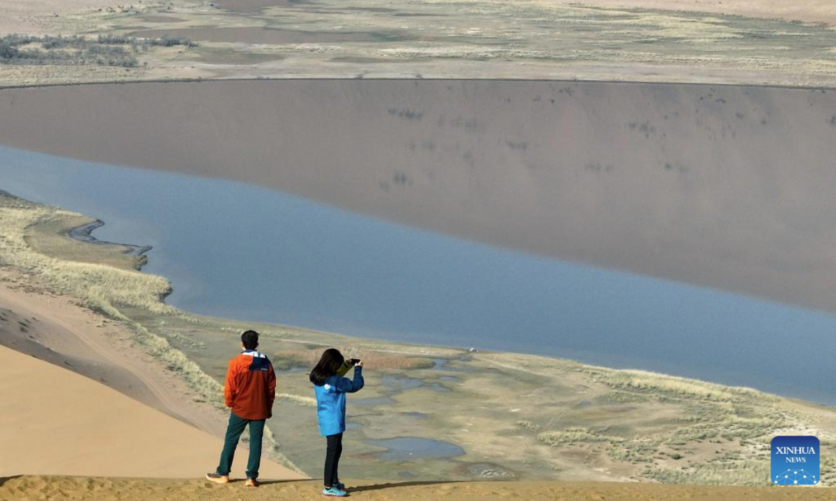 A drone photo taken on Oct. 22, 2025 shows tourists enjoying the scenery of the Badain Jaran Desert in Alxa Right Banner, the Alxa League of north China's Inner Mongolia Autonomous Region. The Badain Jaran Desert was included on the World Heritage List in July 2024. (Xinhua/Bei He)