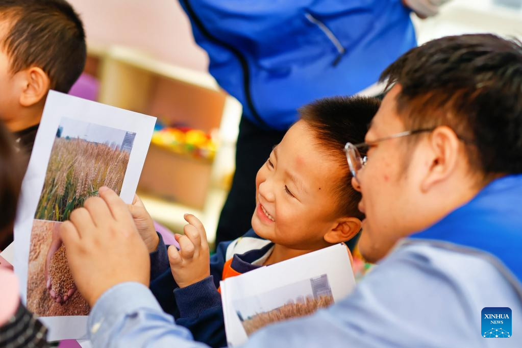 A child learns to identify grains under the guidance of a volunteer at a kindergarten in Tianjin, north China, on Oct. 14, 2025. Theme events have been carried out across China to mark World Food Day that falls on Oct. 16. (Photo by Du Penghui/Xinhua)