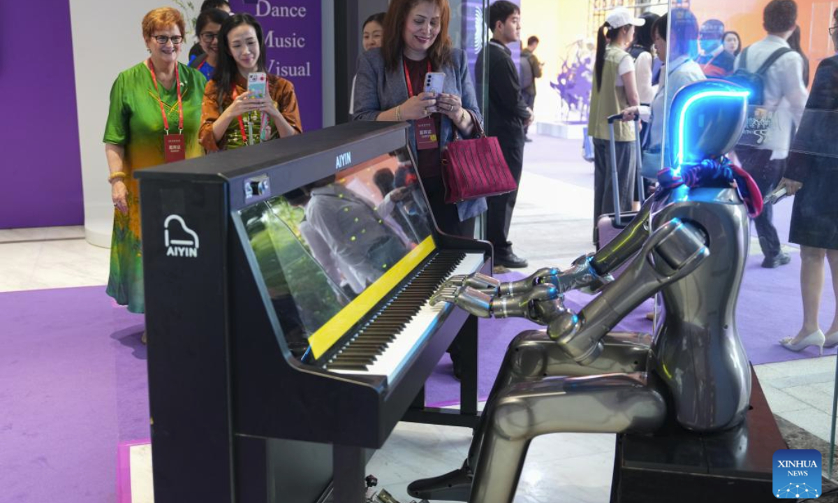 Guests watch a robot playing piano during the World Poetry, Dance, Music and Visual Arts Salon in Hangzhou, east China's Zhejiang Province, Oct. 18, 2025. The World Poetry, Dance, Music and Visual Arts Salon was held here on Saturday as a sideline event of the third Liangzhu Forum. The salon features performances and civilization dialogues, with the participation of more than 20 international artists and cultural scholars. (Xinhua/Huang Zongzhi)