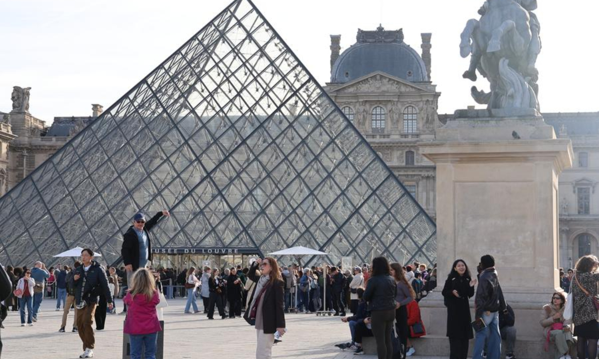 Tourists are pictured in front of the Louvre Pyramid in Paris, France, Oct. 22, 2025. The Louvre Museum reopened to visitors on Wednesday morning, three days after a jewelry theft that caused extensive losses. (Xinhua/Zhang Baihui)
