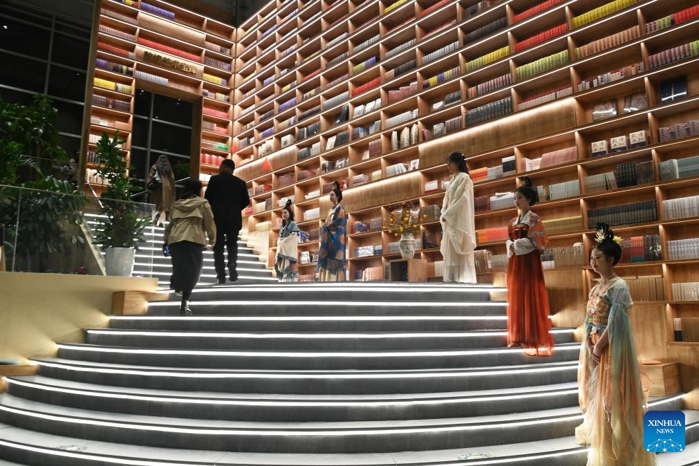 Tourists visit the Dunhuang Unbounded art gallery in Dunhuang, northwest China's Gansu Province, Oct. 11, 2025. In recent years, Dunhuang has advanced the development of immersive cultural and tourism experience projects. By renovating unused buildings, new cultural landmarks centered on Dunhuang culture have been created, including the Dunhuang Book Center, Dunhuang Press, and Dunhuang Unbounded art gallery. These cultural attractions combining cultural consumption, art exhibitions, interactive experiences, and social activities attract a large number of visitors. (Photo: Xinhua)