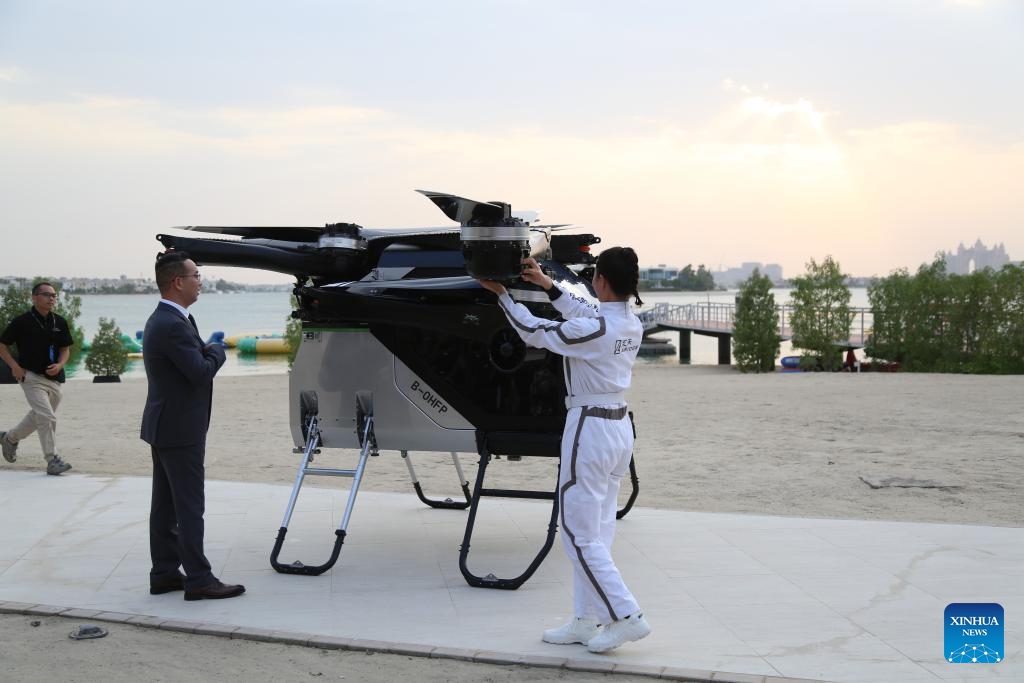 Zhao Deli (L), founder of XPENG AEROHT, opens the gate of a flying car developed by his company with a pilot in Dubai, the United Arab Emirates, Oct. 12, 2025. A flying car developed by Chinese company XPENG AEROHT on Sunday took to the skies over Dubai, the United Arab Emirates (UAE), marking a significant step in the global reach of China's low-altitude aircraft technology. (Photo: Xinhua)