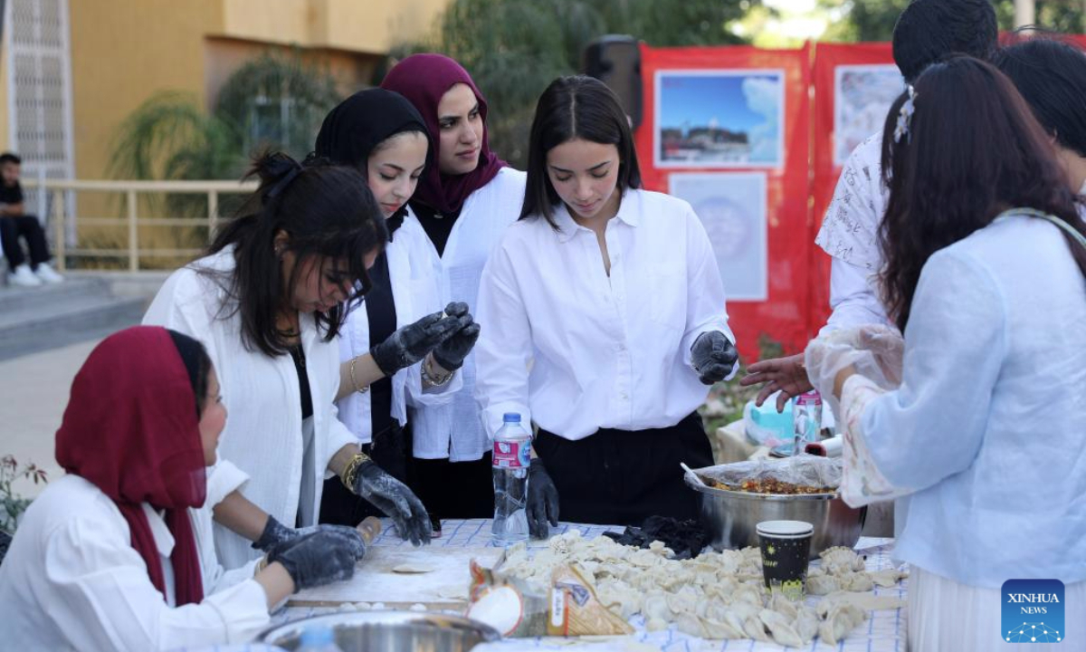 Students learn to make Chinese dumplings during a Chinese cultural event held at Badr University in Cairo, Cairo Governorate, Egypt, on Oct. 20, 2025. The Badr University in Cairo on Monday held a Chinese Culture Festival at its campus, with exhibition stands of Chinese calligraphy, paper-cutting and handicrafts, as well as activities including Chinese martial arts performance and ethnic costumes show, attracting lots of students and teachers. (Xinhua/Sui Xiankai)