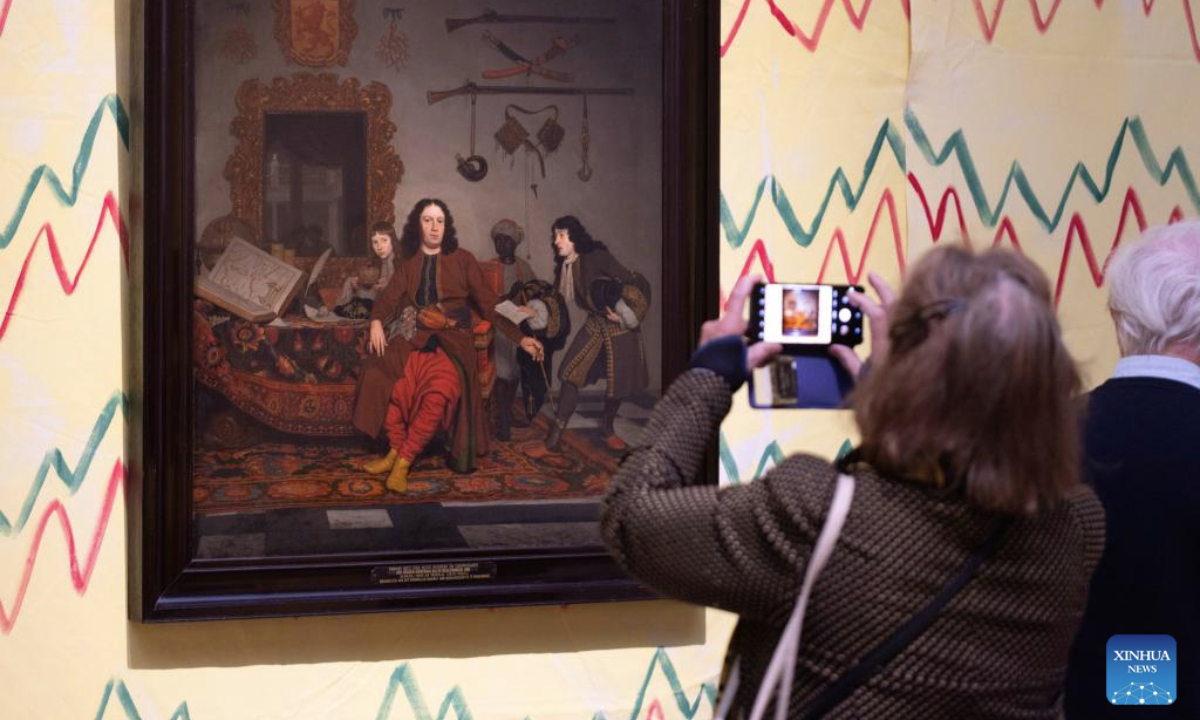 A visitor takes photos of a painting during the media preview of the exhibition At Home in the 17th Century at the Rijksmuseum in Amsterdam, the Netherlands, Oct. 14, 2025. The exhibition, which showcases the lives of people in the Netherlands in the 17th century, will be open to the public from Oct. 17, 2025 to Jan. 11, 2026. (Photo by Sylvia Lederer/Xinhua)