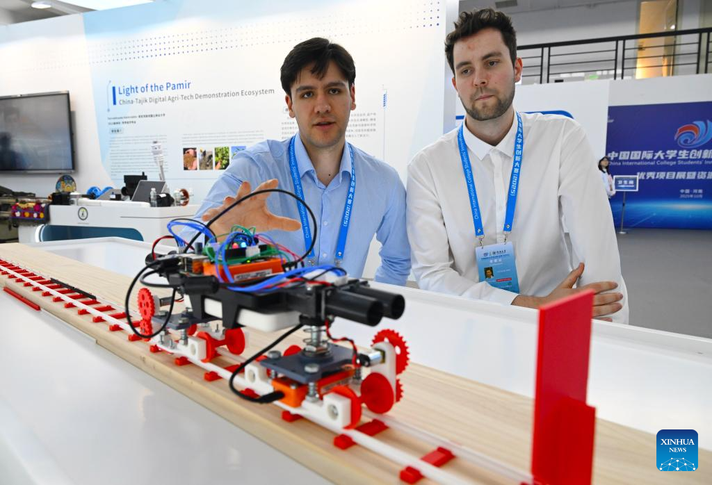 Representatives from the University of Auckland introduce the model of their project during a college students' innovation achievements exhibition in Zhengzhou, central China's Henan Province, Oct. 14, 2025. Six teams from domestic and international colleges took part in the final of the competition here on Wednesday. (Xinhua/Hao Yuan)