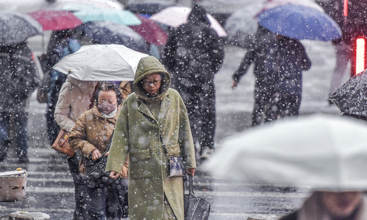 Residents walk in the rain and snow in Urumqi, Northwest China's Xinjiang Uygur Autonomous Region on October 15, 2025. Under the influence of cold air, many places in Xinjiang, including Altay prefecture, Shihezi and Urumqi, witnessed its first snowfall since the beginning of autumn in 2025. Photo: VCG