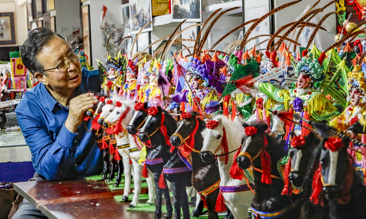 Zhang Guoqin checks on the Shehuo miniatures  Photos: Courtesy of Zhang Guoqin