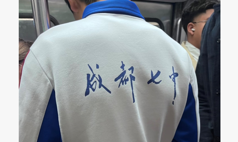 A boy wearing a Chinese senior high school's uniform with Chinese characters 