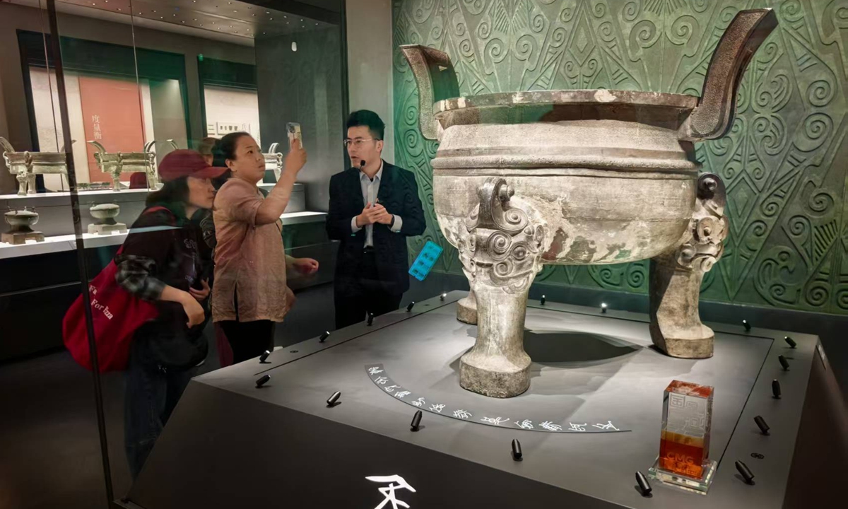 Visitors listen to a guide and take pictures of a precious bronzeware dated back to Zhou Dynasty (1046BC-221BC) at Anhui Museum in Hefei, East China's Anhui Province, on October 16, 2025. Photo: Liu Yang/GT