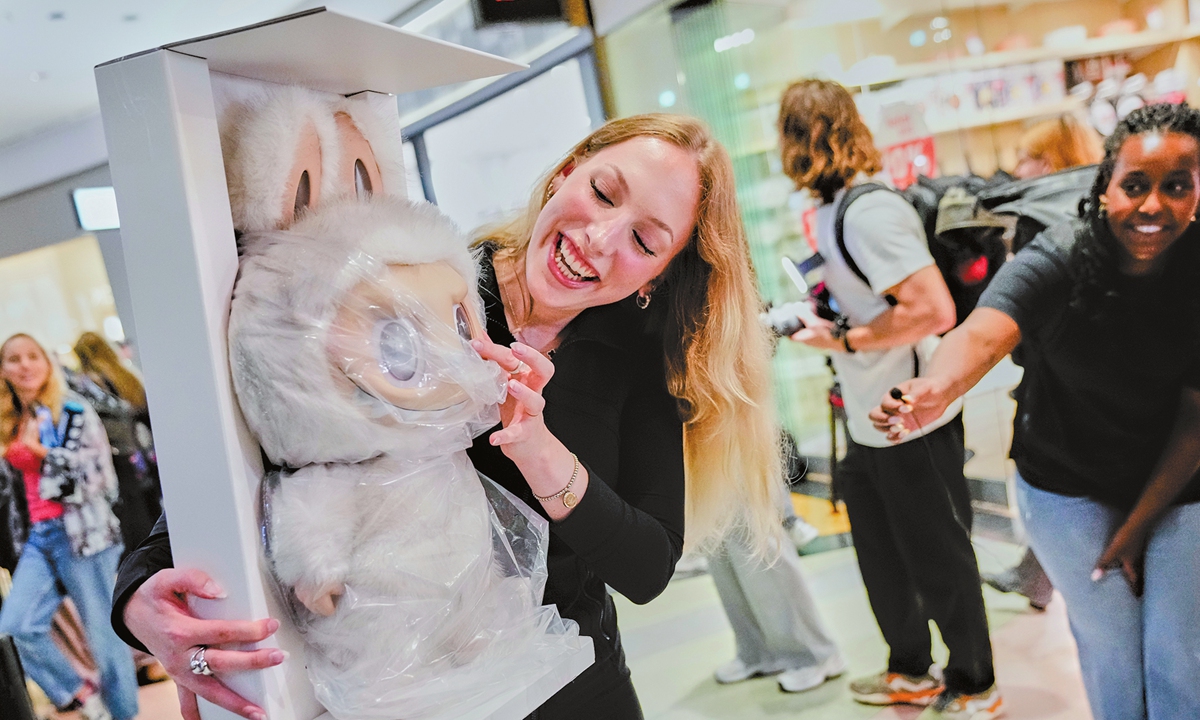 A client shows her Labubu doll to media during the opening of Germany's first shop for Labubu plush dolls in Berlin, Germany, on July 25, 2025.