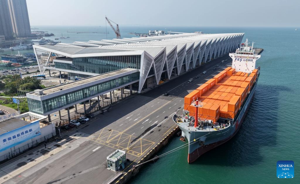 A drone photo taken on Oct. 16, 2025 shows the SMC RIZHAO ship performing the maiden voyage of the Qingdao-Jeju container shipping route berthing at the Qingdao International Cruise Terminal in Qingdao, east China's Shandong Province. A regular direct container shipping route between Qingdao and South Korea's Jeju was launched on Thursday. This express shipping route will operate once a week in its initial stage, significantly enhancing the logistics efficiency between the two places, effectively reducing logistics costs, and further densifying the shipping network of east China's Shandong Province to South Korea. (Xinhua/Li Ziheng)
