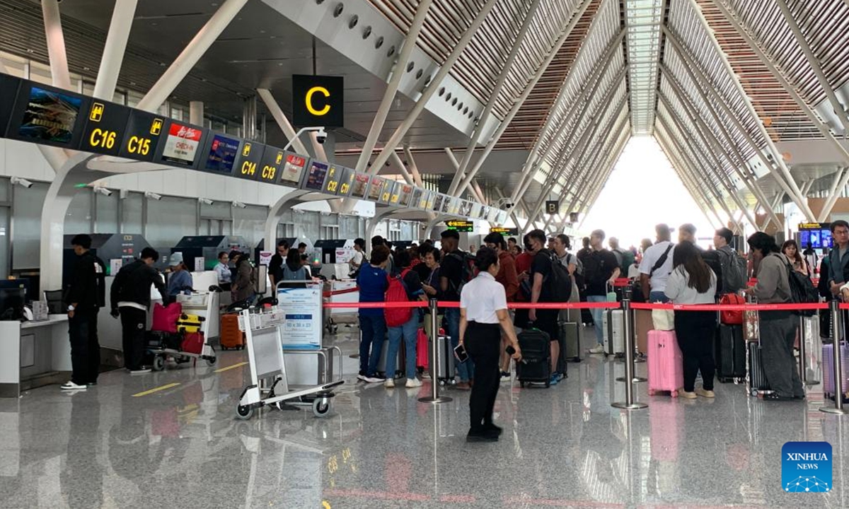Passengers queue to check in at the Siem Reap Angkor International Airport in Siem Reap province, Cambodia on Oct. 16, 2025. The Chinese-invested Siem Reap Angkor International Airport (SAI) on Thursday marked the second anniversary of its operations. (Photo by Van Pov/Xinhua)