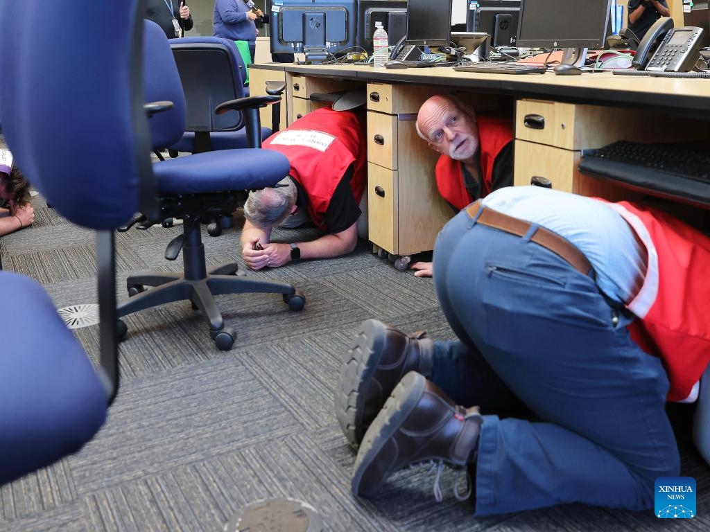 Staff members at the City of Los Angeles Emergency Operations Center follow instructions during an earthquake drill, practicing the Drop, Cover, and Hold On procedure in downtown Los Angeles, California, the United States, Oct. 16, 2025. More than 10 million Californians on Thursday took part in an annual statewide earthquake preparedness drill designed to raise public awareness and strengthen response capabilities for major quakes. (Photo by Qiu Chen/Xinhua)