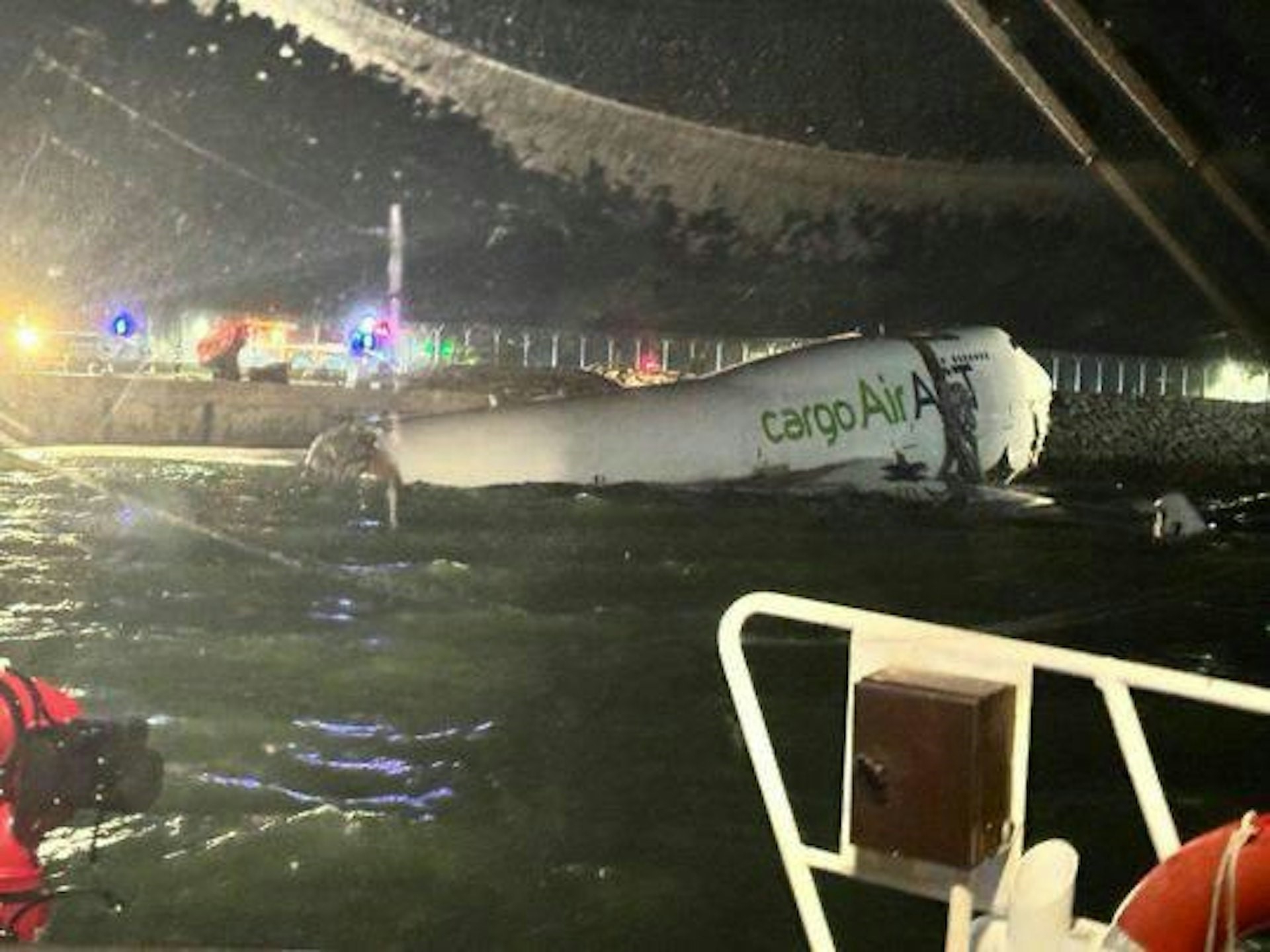 The nose of the cargo plane comes to rest on the shoreline, while the fuselage breaks apart and is left floating in the sea. The tail section's whereabouts remain unknown. Photo: Hong Kong media report 