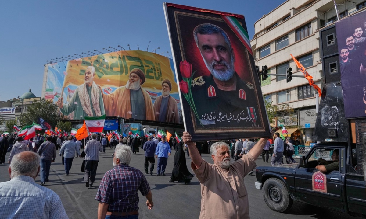 A man holds up a portrait of the late commander of Iran's Revolutionary Guard aerospace division Gen. Amir Ali Hajizadeh, who was killed in an Israeli strike in June during an anti-Israeli rally after the Friday prayers at the Enqelab-e-Eslami (Islamic Revolution) square, in Tehran, Iran, on October 10, 2025. Photo: VCG