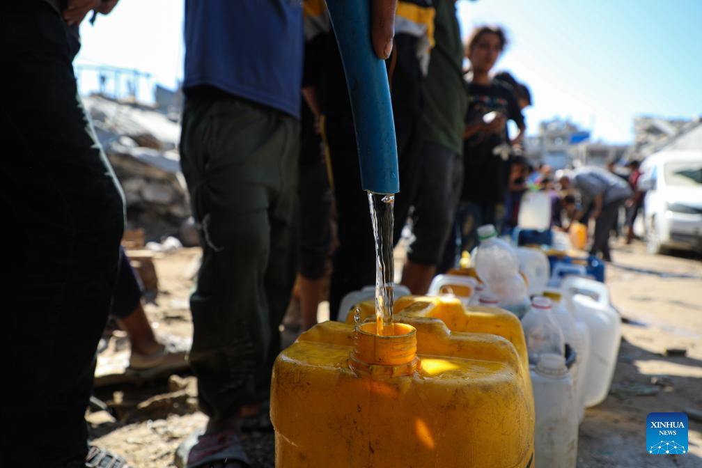 Palestinians queue in the Shati refugee camp, west of Gaza City, to fill up on water, Oct. 28, 2025. Palestinians may have to wait hours for a small amount of water, which is largely unavailable due to damage to water networks caused by Israeli bombing during the war. (Photo by Rizek Abdeljawad/Xinhua)