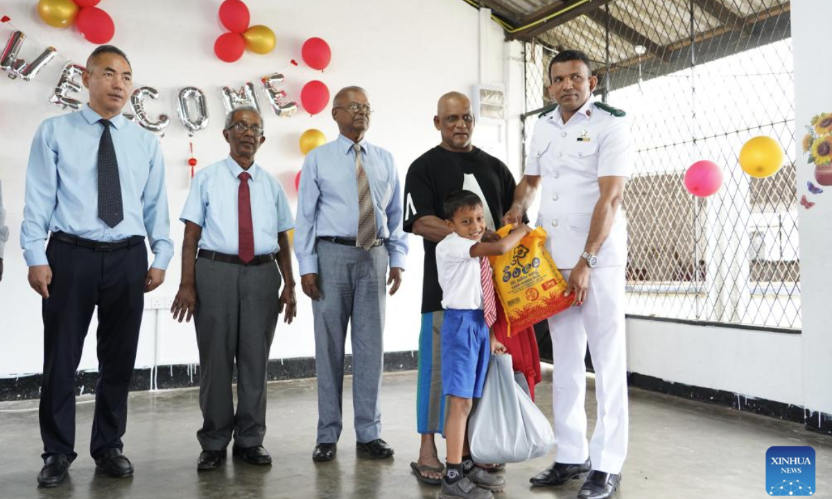 A student from Mihindu Road Sinhala School (2nd R) is awarded scholarship provided by the Amity Foundation, a Chinese-based charity group, in Colombo, Sri Lanka, Oct. 22, 2025. (Xinhua/Chen Dongshu)