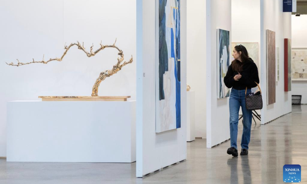A woman visits the Art Toronto 2025 in Toronto, Canada, Oct. 23, 2025. Featuring over 100 international galleries, installations, project spaces and more, the art fair is held here from Oct. 23 to 26. (Photo by Zou Zheng/Xinhua)