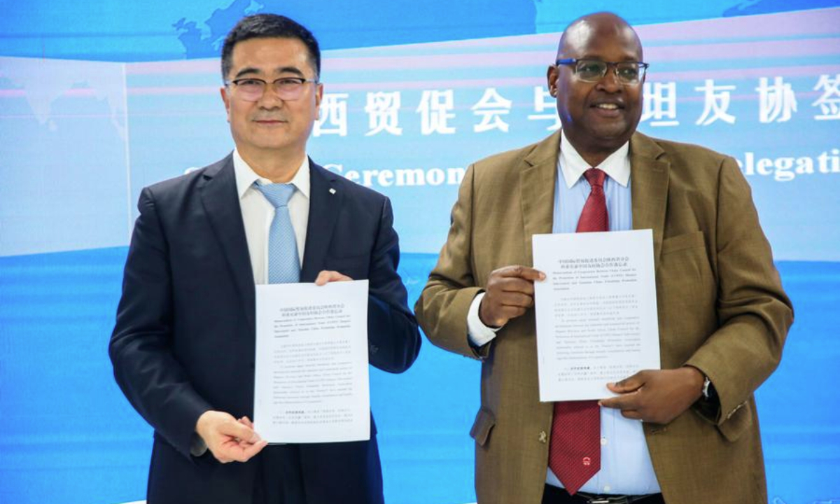 Quan Jian (L), head of the Shaanxi economic and trade delegation, and Joseph Simbakalia, board member of the Tanzania-China Friendship Promotion Association, pose for a photo in Dar es Salaam, Tanzania, Oct. 27, 2025. (Xinhua/Emmanuel Herman)