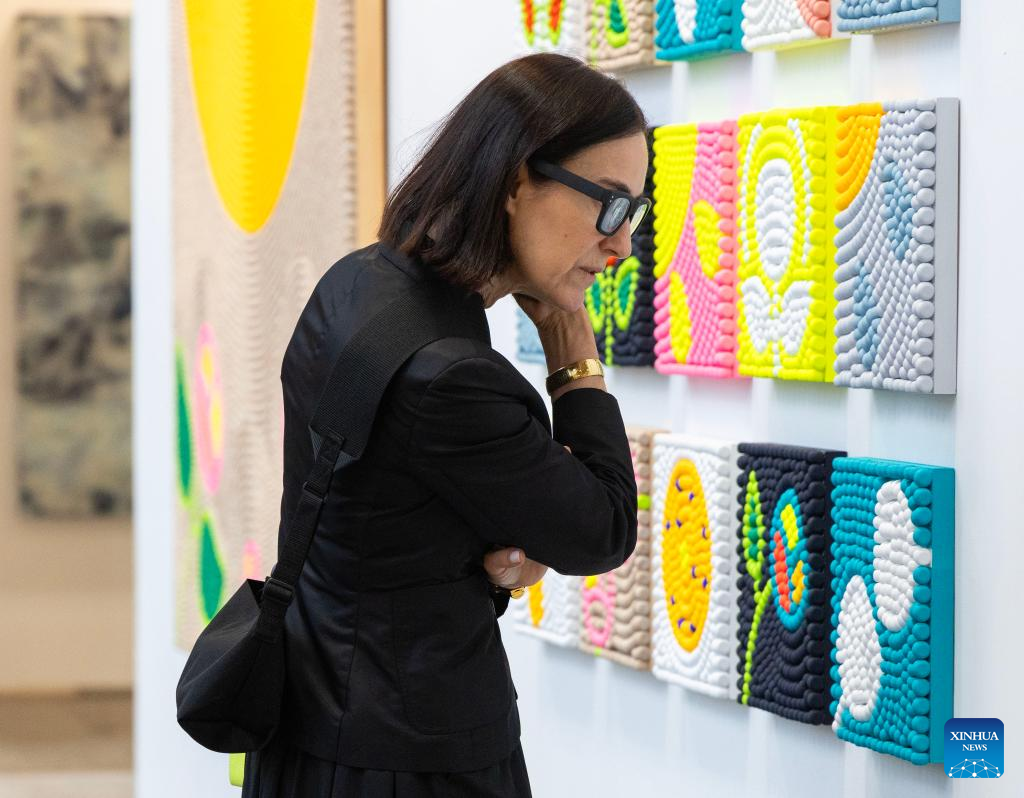 A woman looks at an artwork during the Art Toronto 2025 in Toronto, Canada, Oct. 23, 2025. Featuring over 100 international galleries, installations, project spaces and more, the art fair is held here from Oct. 23 to 26. (Photo by Zou Zheng/Xinhua)