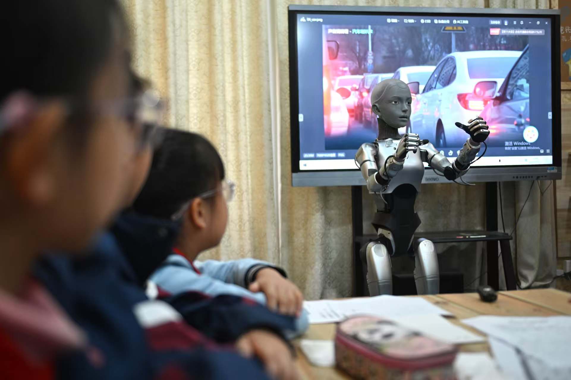 Students at the Primary School Affiliated to Hefei Normal School in Hefei, East China's Anhui Province, listen to humanoid robot 