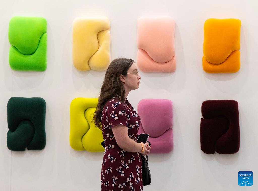 A woman walks past an artwork on display during the Art Toronto 2025 in Toronto, Canada, Oct. 23, 2025. Featuring over 100 international galleries, installations, project spaces and more, the art fair is held here from Oct. 23 to 26. (Photo by Zou Zheng/Xinhua)