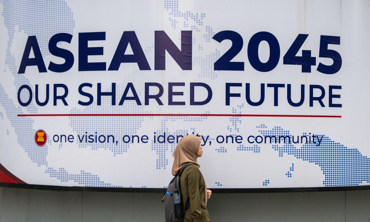 A woman walks in front of a billboard for the Association of Southeast Asian Nations (ASEAN) ahead of the 47th ASEAN Summit in Kuala Lumpur, Malaysia on October 23, 2025. Photo: VCG