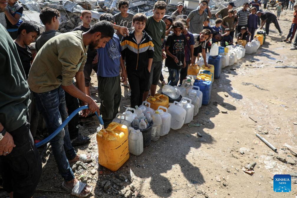 Palestinians queue in the Shati refugee camp, west of Gaza City, to fill up on water, Oct. 28, 2025. Palestinians may have to wait hours for a small amount of water, which is largely unavailable due to damage to water networks caused by Israeli bombing during the war. (Photo by Rizek Abdeljawad/Xinhua)