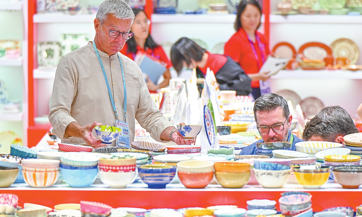 Buyers examine products in the daily-use ceramics exhibition area as the second phase of the 138th China Import and Export Fair opens in Guangzhou, South China's Guangdong Province on October 23, 2025. This phase features more than 10,000 enterprises, showcasing high-quality and distinctive household products and offering global buyers diverse options for refined home furnishings. Photo: VCG