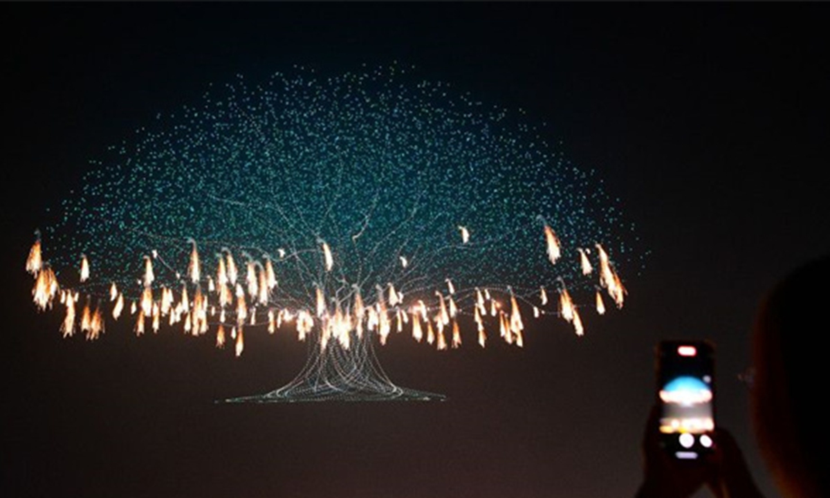 A towering giant tree rises from the ground, with thousands of golden feather fireworks shimmering and dancing within its canopy. Photo: Changsha Evening News