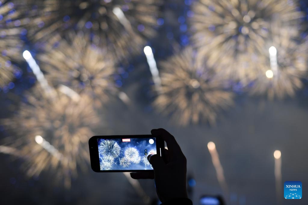 A tourist shoots a video during a firework show in Liuyang City, central China's Hunan Province, Oct. 24, 2025. The opening ceremony of the 17th Liuyang Fireworks Cultural Festival was held here on Friday. Liuyang is well-known for its fireworks industry. (Photo: Xinhua)