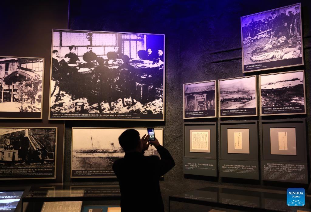 A man takes photos at Unyielding Treasure Island: Loyal to the Motherland, an exhibition on the history of Taiwan compatriots' resistance against Japanese aggression, at the Museum of the War of Chinese People's Resistance Against Japanese Aggression in Beijing, capital of China, Oct. 25, 2025. Featuring 387 archive photographs and 453 cultural relics, the exhibition opened here on Saturday to commemorate the 80th anniversary of Taiwan's restoration to China. (Photo: Xinhua)
