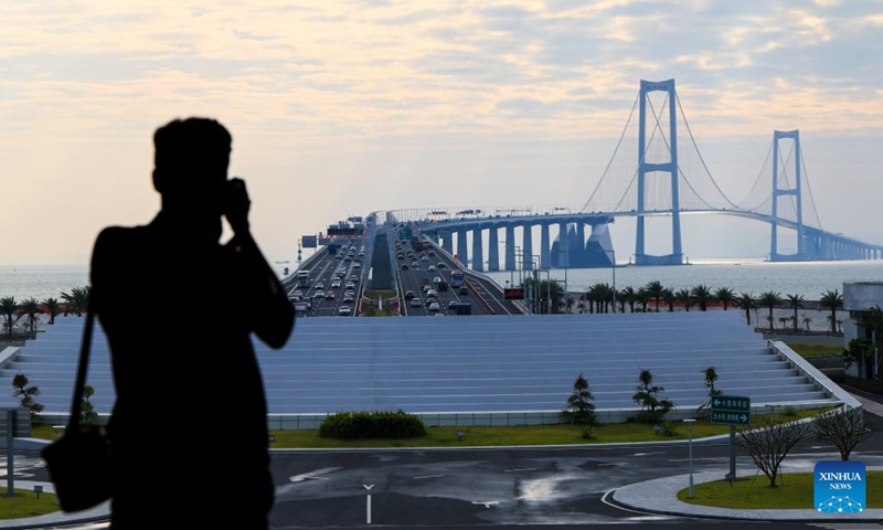 A man takes photos of the Shenzhong Bridge from a viewing platform on the west artificial island of the Shenzhen-Zhongshan Link in south China's Guangdong Province, Oct. 25, 2025. The west artificial island of the Shenzhen-Zhongshan Link started trial operation for tourism on Saturday. The Shenzhen-Zhongshan Link, spanning approximately 24 kilometers, opened to traffic on June 30, 2024. (Photo: Xinhua)