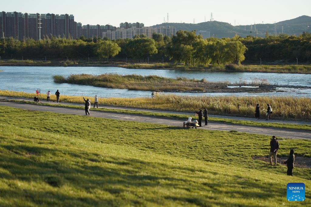 People enjoy themselves by the Yongding River in Shijingshan District of Beijing, capital of China, Oct. 26, 2025. (Photo: Xinhua)