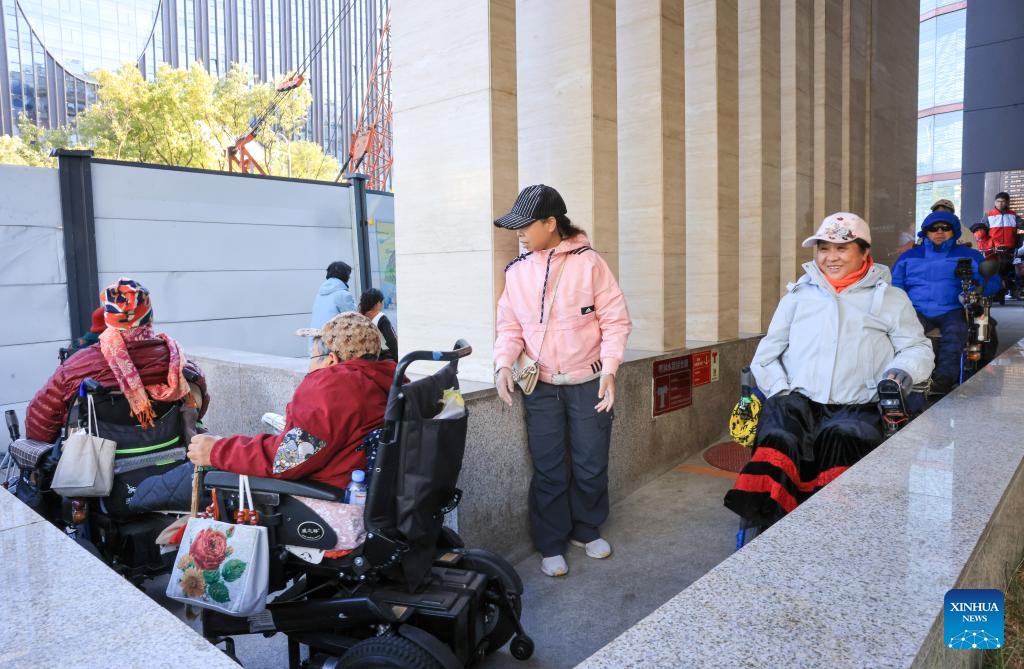 Physically impaired people leave Trojan Fairy restaurant after a film screening in Beijing, capital of China, Oct. 26, 2025. The Trojan Fairy restaurant, which focuses on supporting people with disabilities, hosted a film screening for 52 visually and physically impaired attendees. The event featured narrated audio descriptions to help visually impaired participants visualize scenes.  (Photo: Xinhua)