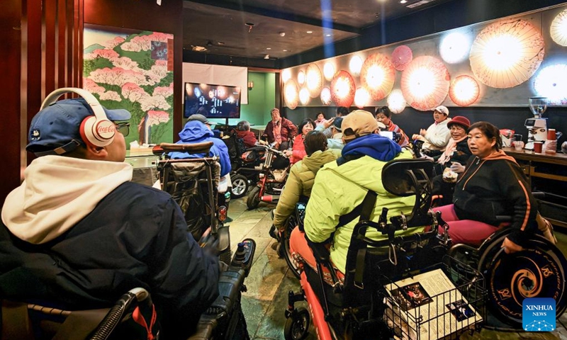 Physically impaired people communicate after a film screening at Trojan Fairy restaurant in Beijing, capital of China, Oct. 26, 2025. The Trojan Fairy restaurant, which focuses on supporting people with disabilities, hosted a film screening for 52 visually and physically impaired attendees. The event featured narrated audio descriptions to help visually impaired participants visualize scenes. (Photo: Xinhua)