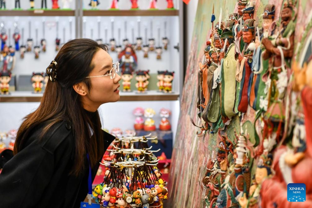 A tourist views dough figurine works, the intangible cultural heritage, in Xinzhou ancient city in Xinzhou, north China's Shanxi Province, on Oct. 21, 2025. Leisure tourism in Xinzhou ancient city remains booming in late autumn. Tourism activities such as bathing in hot springs, taking photos in ancient costumes, and watching intangible cultural heritage performances have attracted many tourists to visit the ancient city for a few days, to deeply immerse themselves in the unique charm of traditional culture. (Photo: Xinhua)