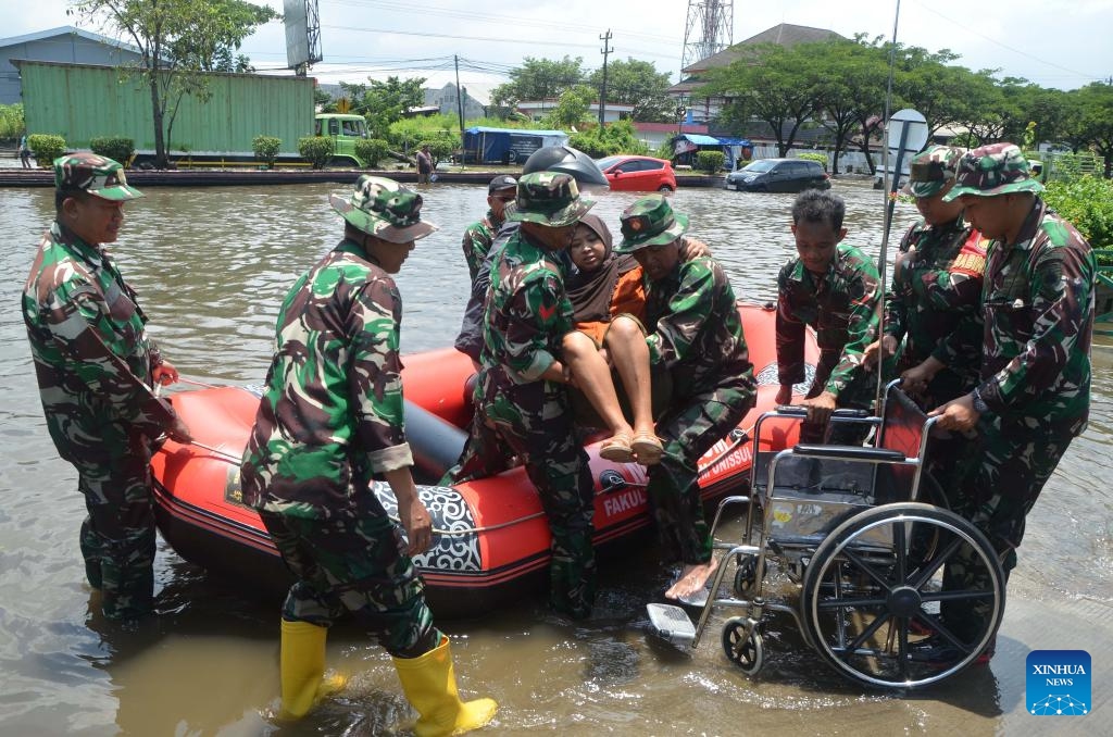 Indonesian army members transfer a woman from a dinghy to a wheelchair after heavy rain hit Semarang, Central Java, Indonesia, Oct. 25, 2025. (Photo: Xinhua)