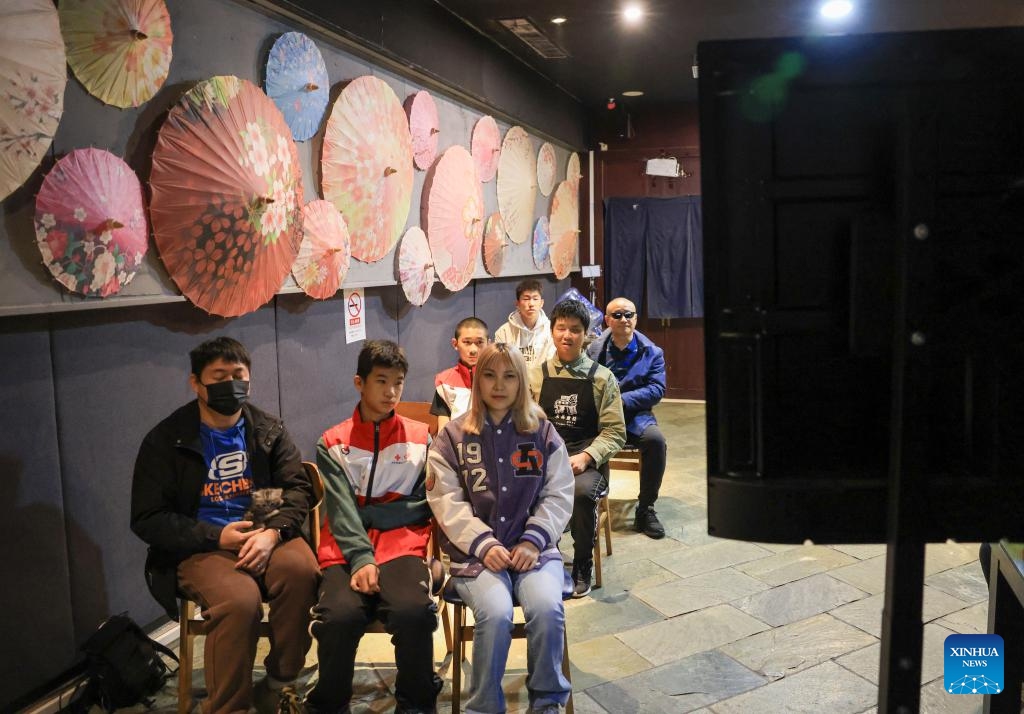 Visually impaired people and volunteers watch a movie with audio description at Trojan Fairy restaurant in Beijing, capital of China, Oct. 26, 2025. The Trojan Fairy restaurant, which focuses on supporting people with disabilities, hosted a film screening for 52 visually and physically impaired attendees. The event featured narrated audio descriptions to help visually impaired participants visualize scenes. (Photo: Xinhua)
