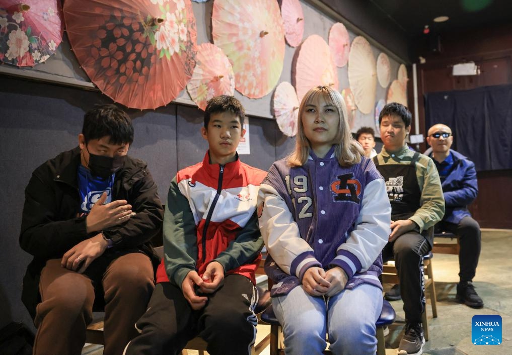 Visually impaired people and volunteers watch a movie with audio description at Trojan Fairy restaurant in Beijing, capital of China, Oct. 26, 2025. The Trojan Fairy restaurant, which focuses on supporting people with disabilities, hosted a film screening for 52 visually and physically impaired attendees. The event featured narrated audio descriptions to help visually impaired participants visualize scenes. (Photo: Xinhua)