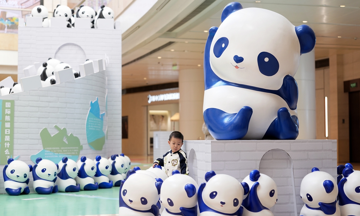 A child plays at a giant panda art installation at the China World Mall in Beijing on October 27, 2025, which marks the 9th International Panda Day. The installation consists of nearly 400 pandas and Great Wall elements, aiming to interpret the concept of harmonious coexistence. Photo: VCG