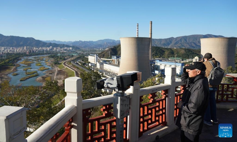 People enjoy the scenery along the Yongding River from a viewing platform in Shijingshan District of Beijing, capital of China, Oct. 26, 2025. (Photo: Xinhua)