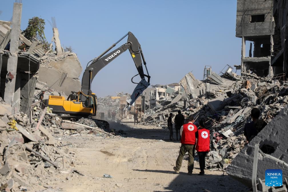 Red Cross members are seen as an Egyptian Excavator is working at al-Tuffah area east of Gaza City, Oct. 27, 2025. Red Cross and Egyptian teams have been allowed to enter the Gaza Strip to search for the bodies of hostages, Israeli government spokesperson Shosh Bedrosian said on Sunday. (Photo: Xinhua)