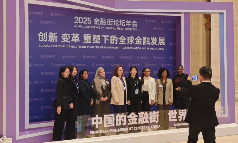 Participants pose for a group photo in front of a display board featuring the logo of the Annual Conference of Financial Street Forum 2025 in Beijing on October 29, 2025. Photo: Yin Yeping/GT