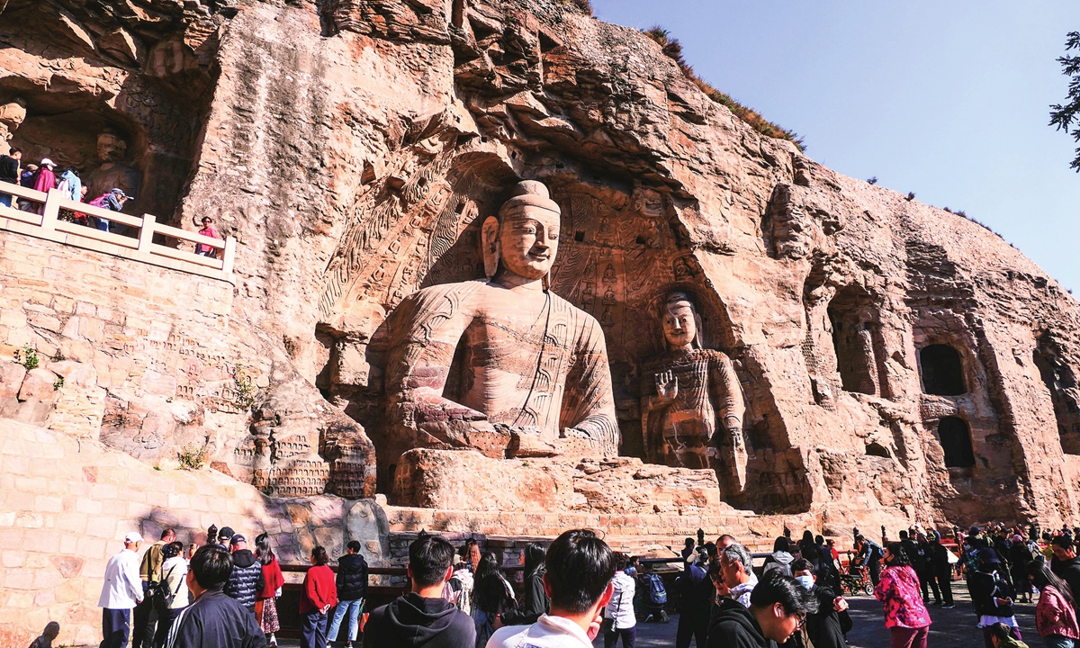 Tourists visit a Buddha statue in Cave 20 of the Yungang Grottoes in Datong, North China's Shanxi Province, on October 14, 2025.