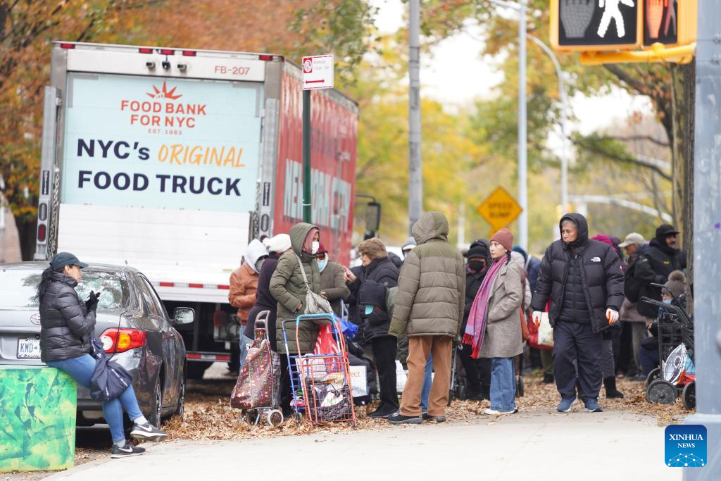 People line up to get free food items at a distribution station in New York, the United States, on Nov. 12, 2025. People received free food items from a distribution station of the Food Bank for New York city on Wednesday. (Xinhua/Zhang Fengguo)