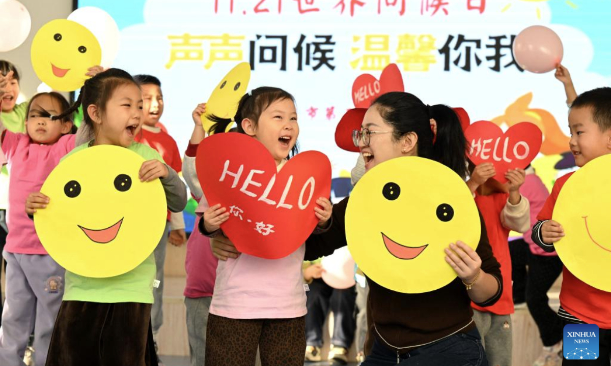 A teacher and children greet each other to celebrate the upcoming World Hello Day, which falls on Nov. 21 annually, at a kindergarten in Shijiazhuang, north China's Hebei Province, Nov. 20, 2025. (Photo by Chen Qibao/Xinhua)