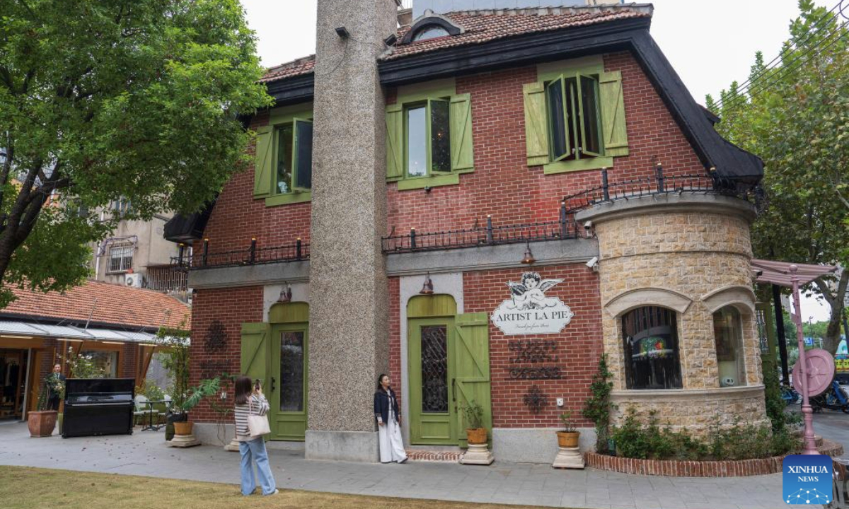 A visitor poses for photos at the Yuyuan Road Historical and Cultural Block in east China's Shanghai, Nov. 12, 2025.

The Yuyuan Road Historical and Cultural Block is a well-known neighborhood in the city's downtown area. In recent years, the block has consistently pursued an urban renewal philosophy that integrates art into daily life. By introducing independent bookstores, cafes, art studios, and other establishments, it now boasts around 80 distinctive shops, making it a must-visit destination for Shanghai's artistic youth and travelers. (Xinhua/Cai Yang)