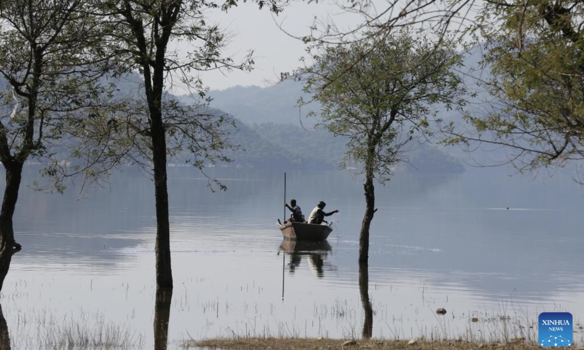 Fishermen cast their fishing net in Phangota Lake, in Pathankot district of India's northern Punjab state, Nov. 12, 2025. (Str/Xinhua)