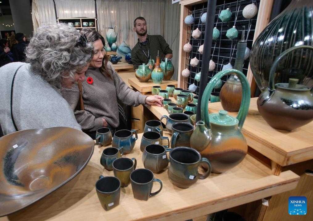 People view ceramics at the 2025 edition of the Circle Craft Holiday Market in Vancouver, British Columbia, Canada, Nov. 11, 2025. The 2025 edition of the Circle Craft Holiday Market kicked off here on Tuesday and runs until Nov. 16. (Photo by Liang Sen/Xinhua)